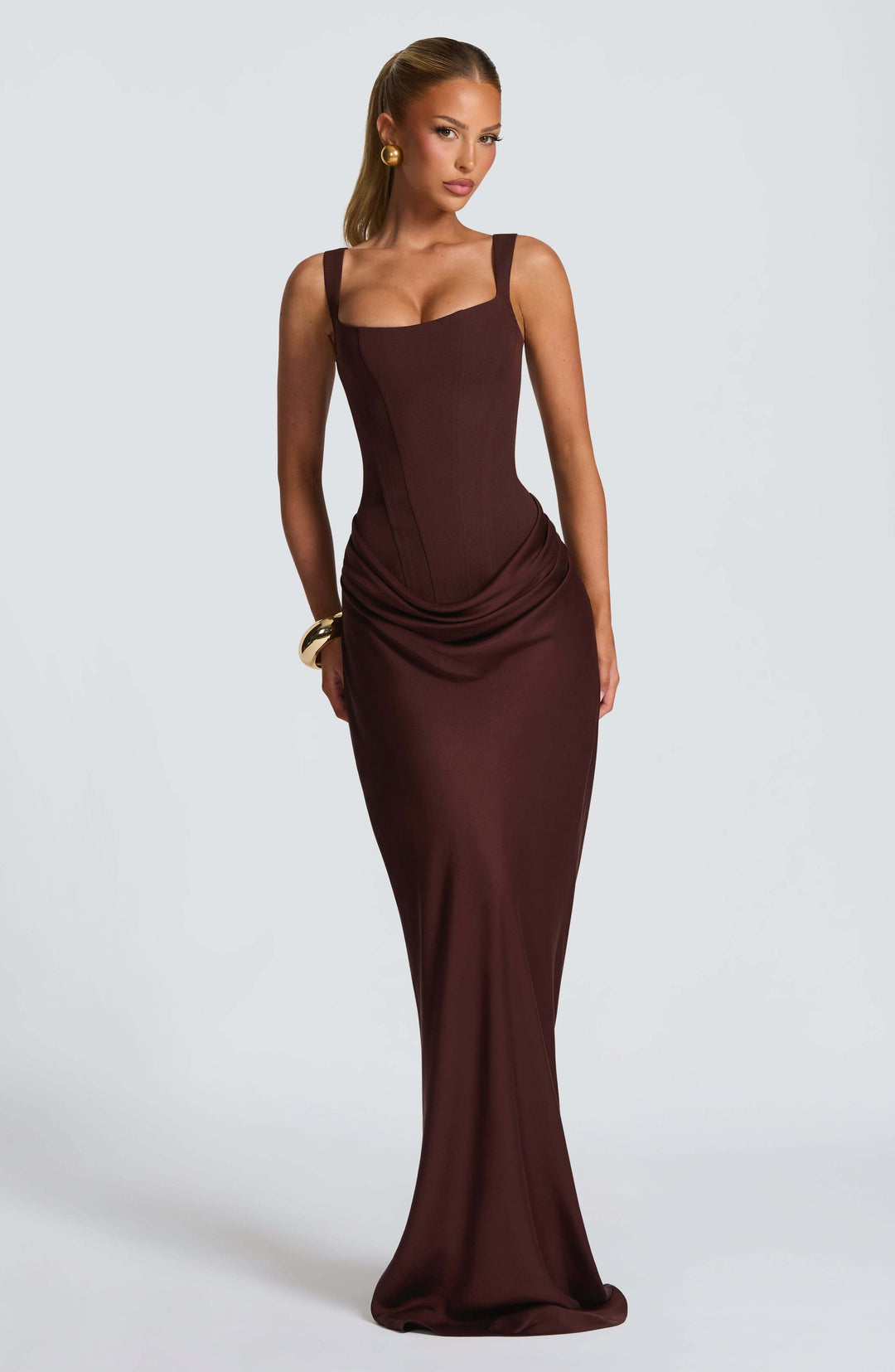 Woman gracefully posing in a chic Corset Maxi Wedding Guest Dress with open back, perfect for formal events.