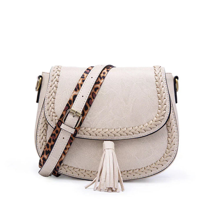 White versatile women's crossbody bag with a chic tassel. An elegant fashion accessory, perfect for any occasion.