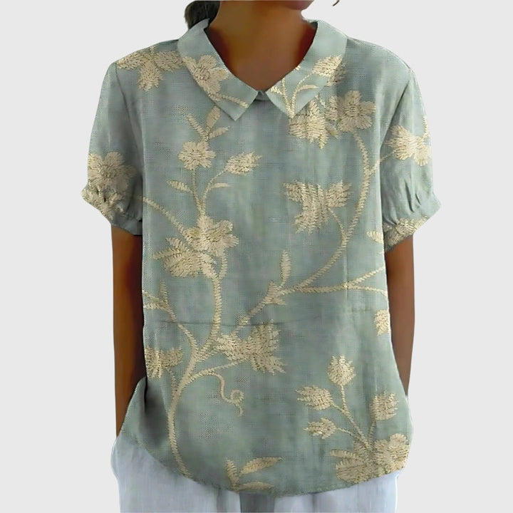 Detail of stylish sleeves & cuffs on a women's floral printed blouse, adding an elegant touch.
