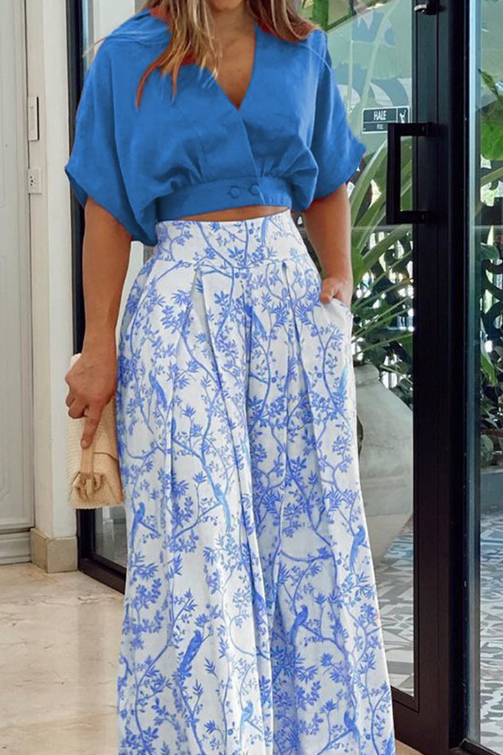 Stylish black women's floral two-piece set featuring an elegant crop top and flowing maxi skirt.