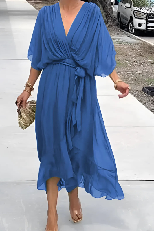 Back view of a women's elegant flowing maxi dress in motion, showcasing its long, comfortable design for parties.