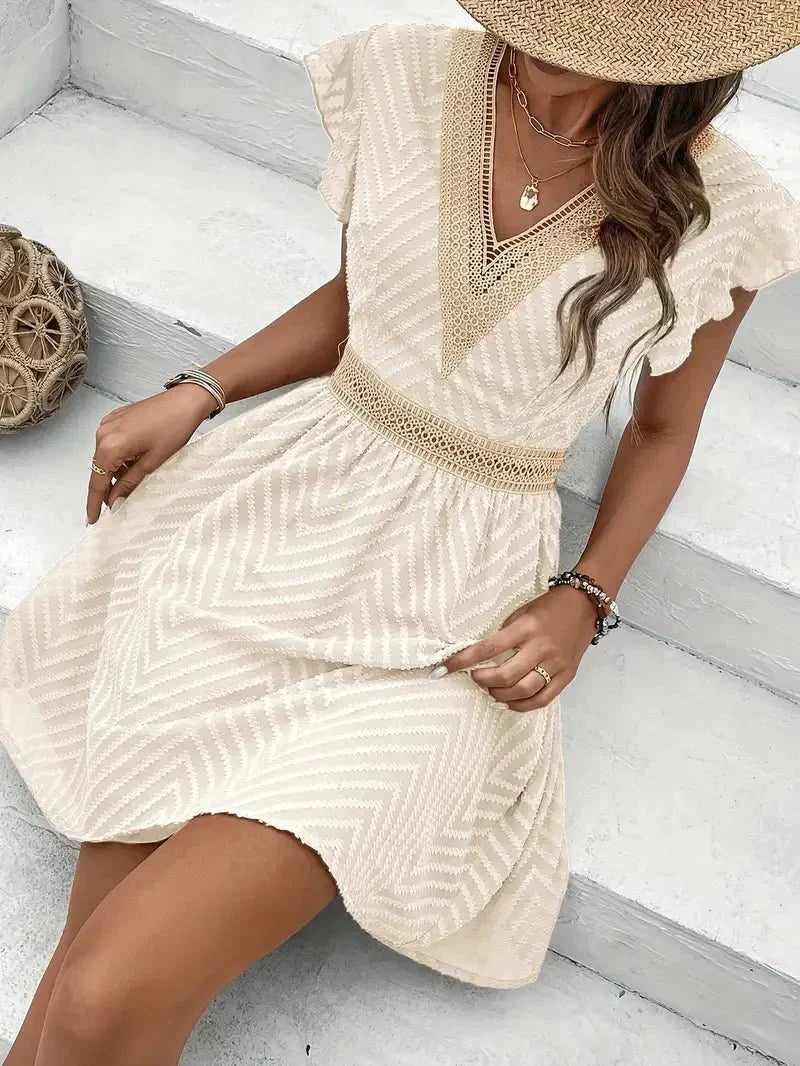 Beautiful women's flutter sleeve mini dress. V-neck, flared skirt, perfect for elegant summer wear.