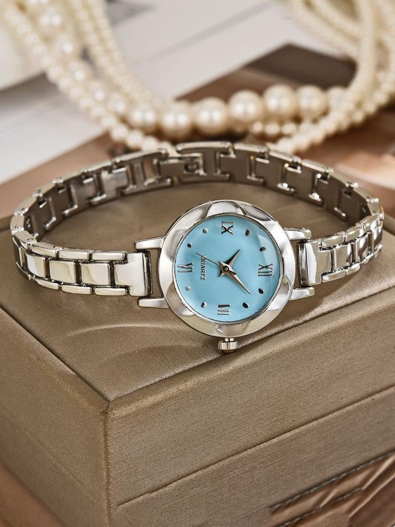 Close-up of a women's elegant gold bracelet watch, showcasing the intricate band and black dial.
