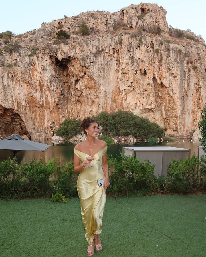 Sophisticated women's gold off-shoulder maxi dress, a chic long evening wear option for formal events & parties.