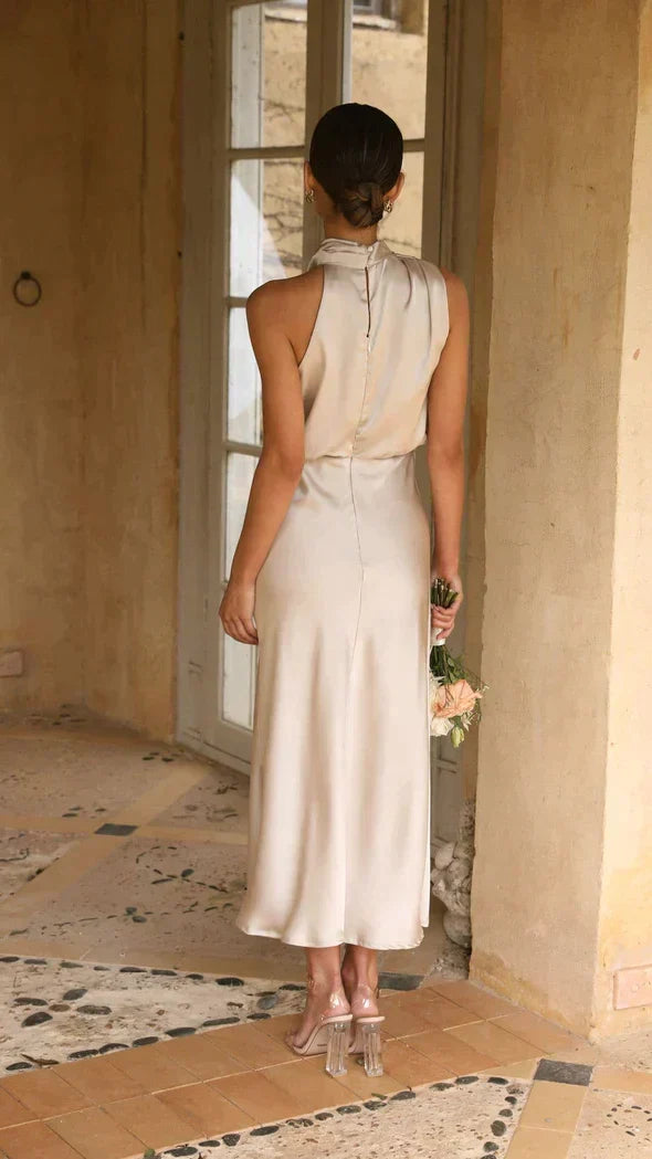 Chic women's halter midi dress featuring a draped neckline and elegant flowing skirt for summer events.