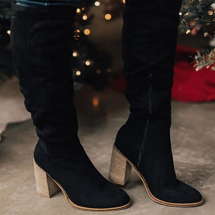 Women's elegant knee-high boots for fall and winter style. Features a fashionable block heel and slip-on design.
