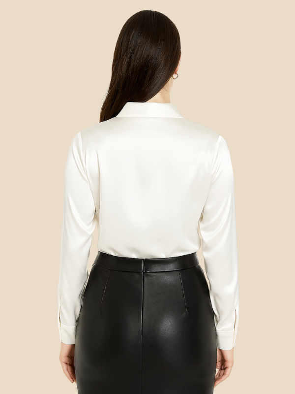 Women's long sleeve button-up blouse paired with jeans for a casual chic style.