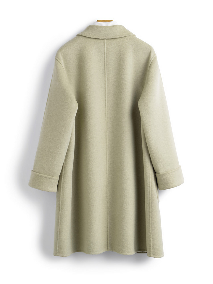 Close-up of the plush cashmere fabric on a women's luxury longline winter coat, highlighting its texture.