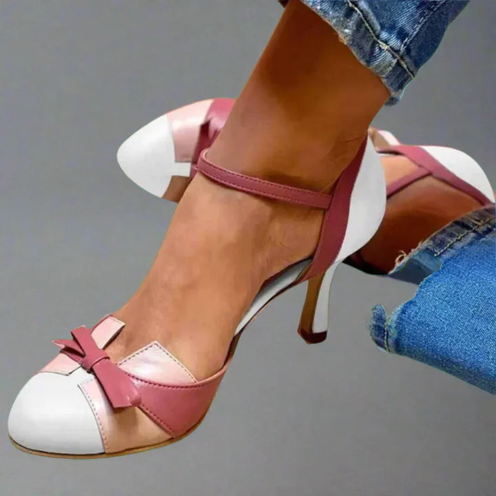 Women's sophisticated mid heel pumps featuring a chic bow strap. Versatile elegant footwear for dressy occasions or work.