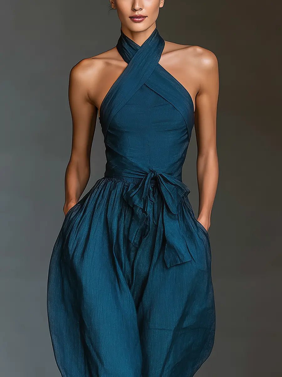 Formal women's navy blue halter neck jumpsuit with wide leg pants, a chic sleeveless choice for elegant evening events.