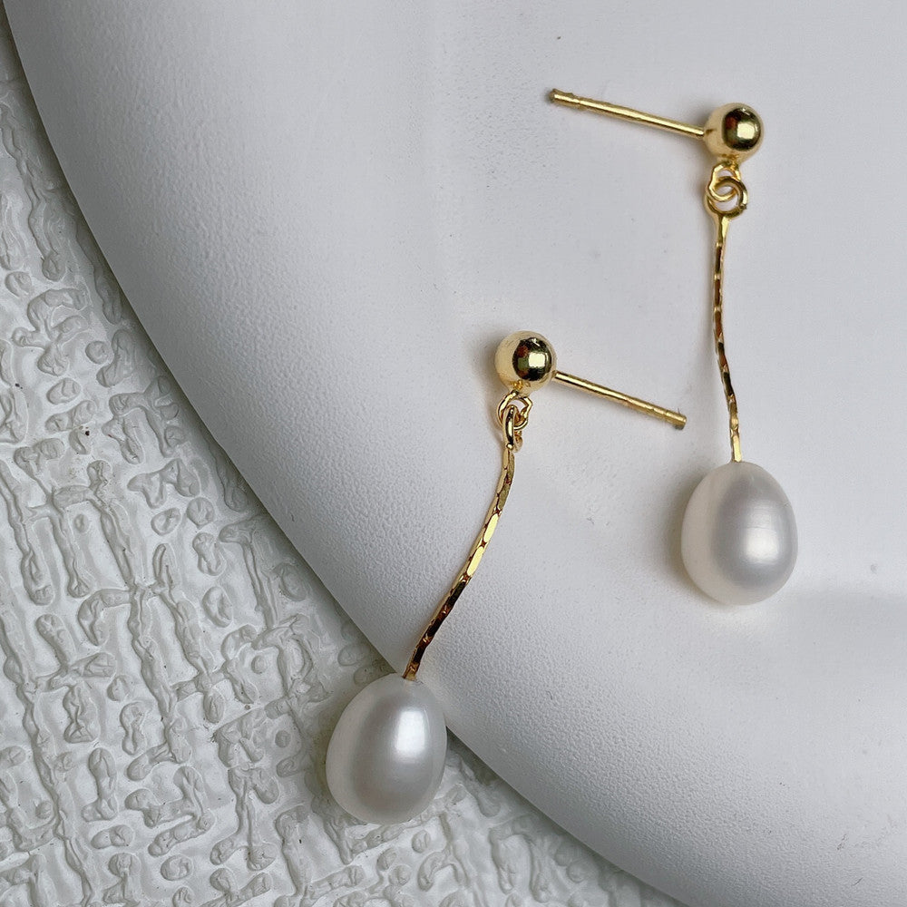 Elegant women's pearl stud earrings with delicate gold setting, perfect for classic & timeless style. A chic accessory.