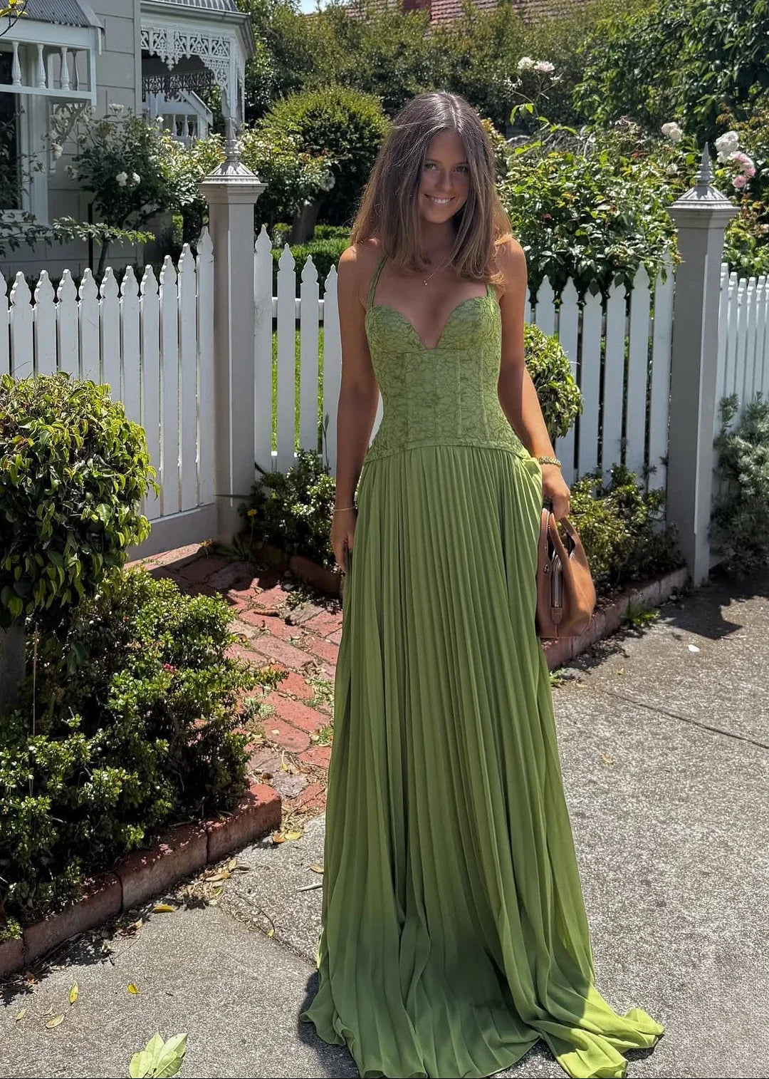Green pleated halter maxi dress with corset-style bodice for women, ideal for a wedding guest or special occasion.