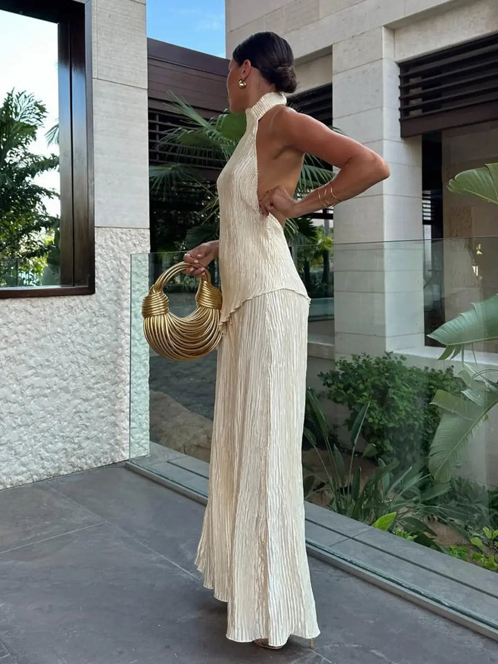 Sophisticated women's co-ord pleated set with a chic halter neck top and flowy wide-leg pants for formal wear.