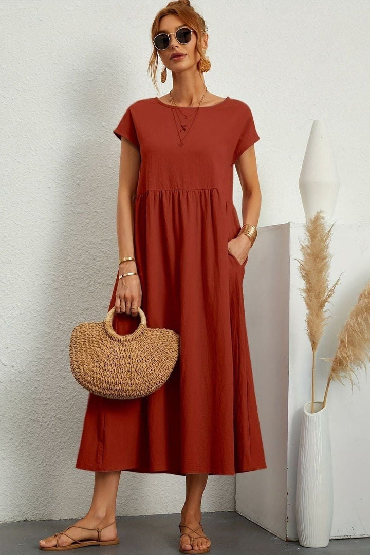 Side view of a women's pleated midi dress, highlighting the fluid movement of the comfortable fabric.