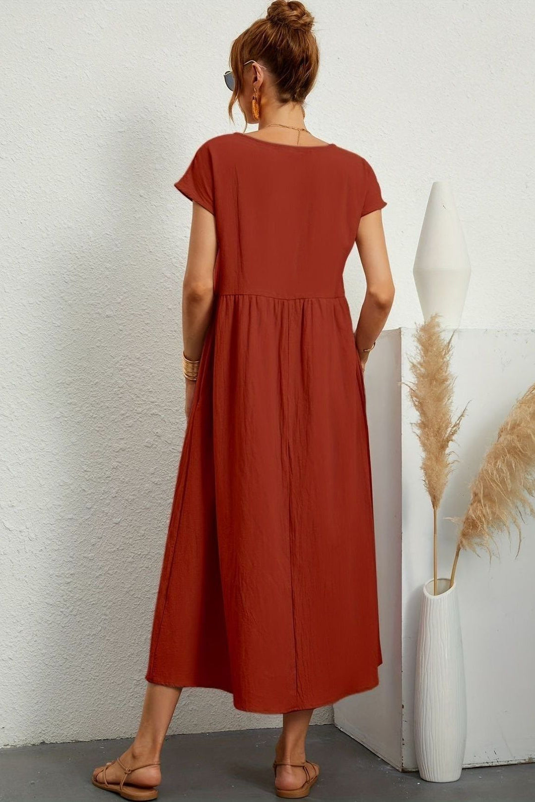 Back view of a women's elegant pleated midi dress, perfect for a chic & relaxed spring/summer look.