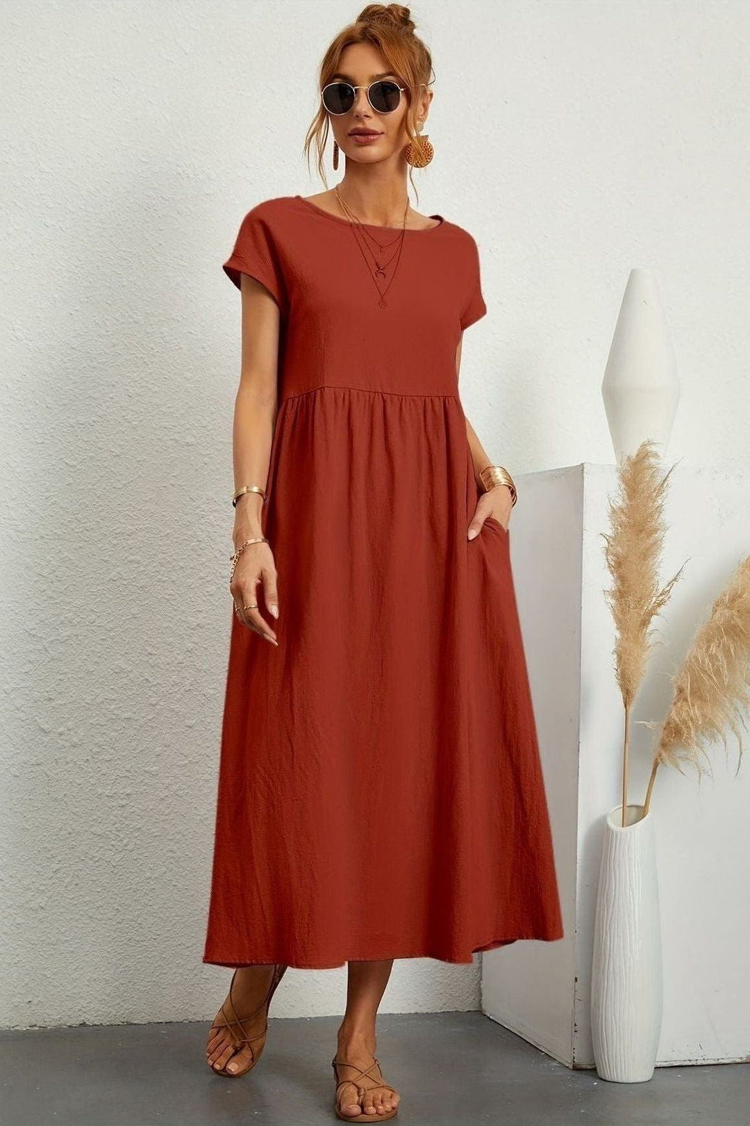 Close-up of the delicate pleats on a women's elegant midi dress, showing quality & design.