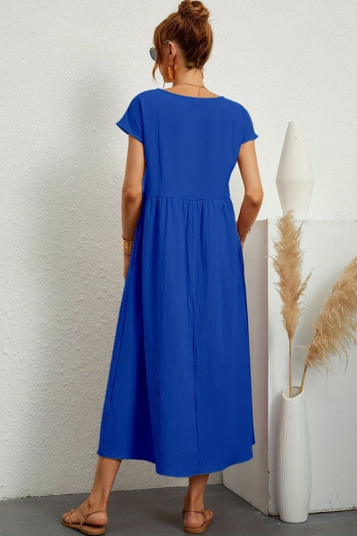 Model wearing a flowy women's pleated midi dress, showing its comfortable movement & elegant style.