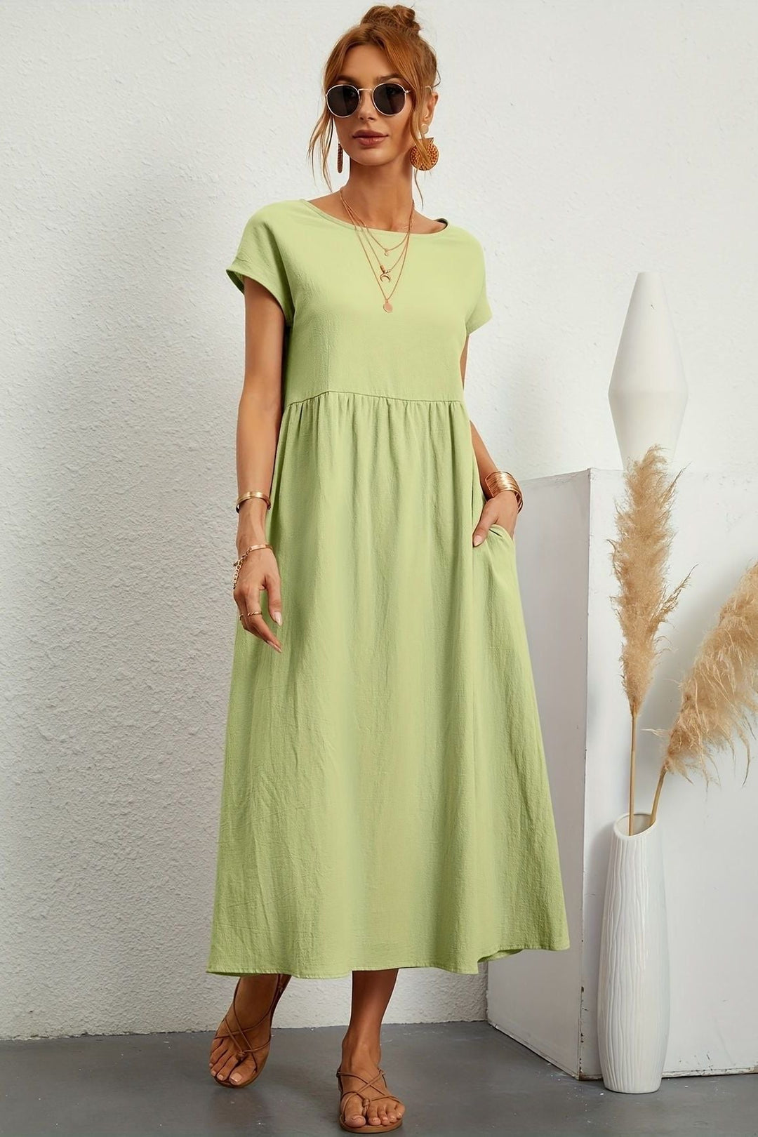 Modern women's elegant pleated midi dress, blending comfort with contemporary fashion. Relaxed style.