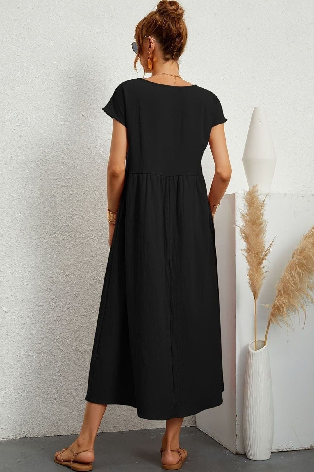 Front view of an elegant women's pleated midi dress, showcasing its flattering silhouette & pleats.