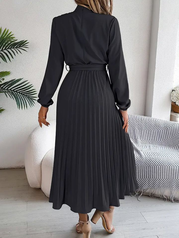 Modest women's pleated midi dress with long sleeves and a belt. Perfect for formal or casual autumn outfits.