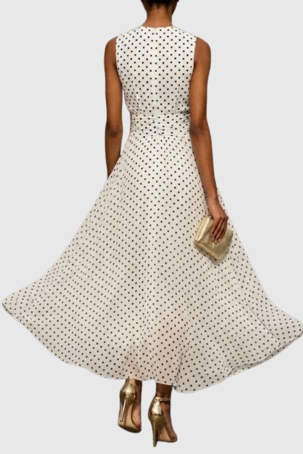 Sophisticated sleeveless polka dot maxi dress with a flowing ruffle hem, ideal for wedding guests.