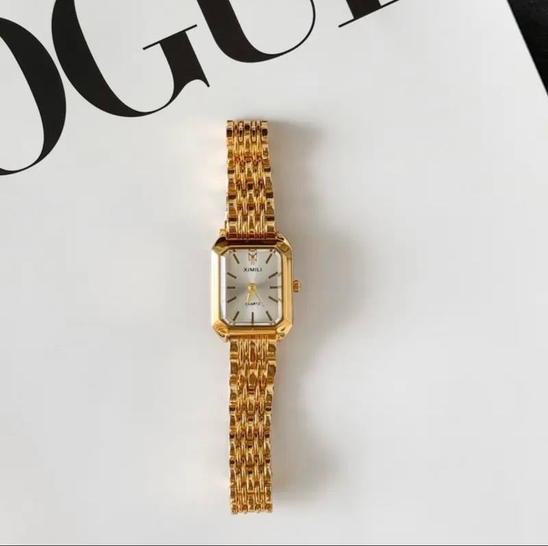 Fashionable women's gold-tone rectangular watch, perfect for an elegant look, shown on a wrist.