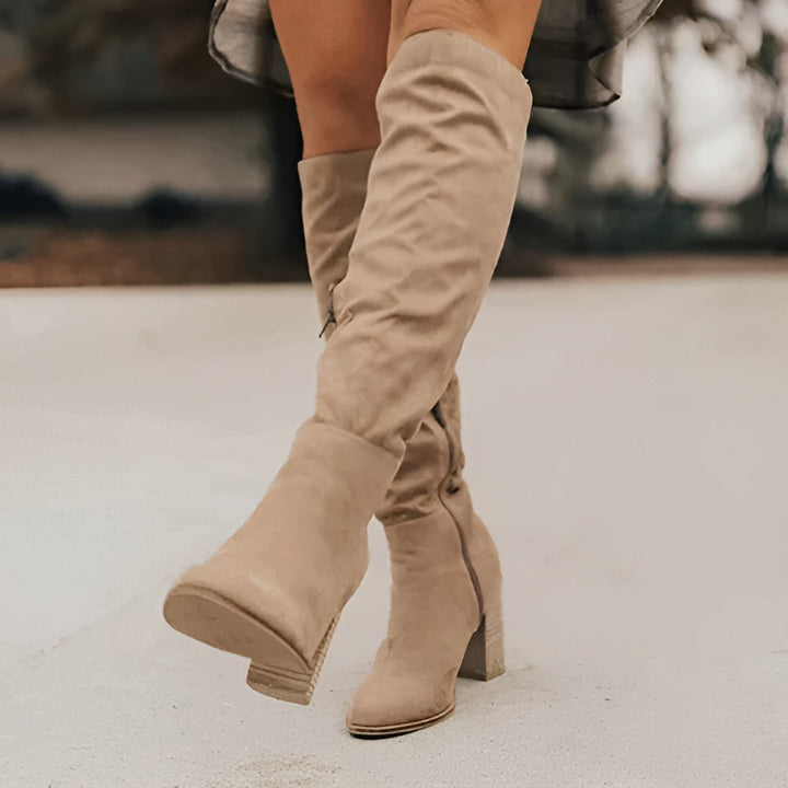Women's knee-high boots with a sleek design, made from plush burgundy suede for a chic fall outfit.