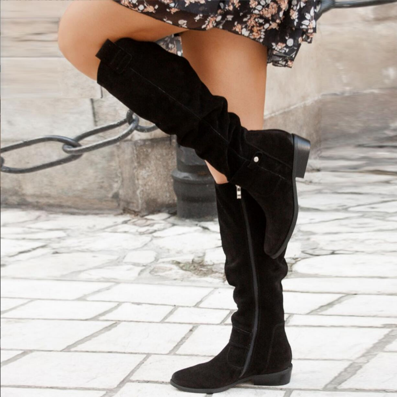 Detailed shot of the shaft and heel of women's suede knee-high boots, showcasing elegant footwear.