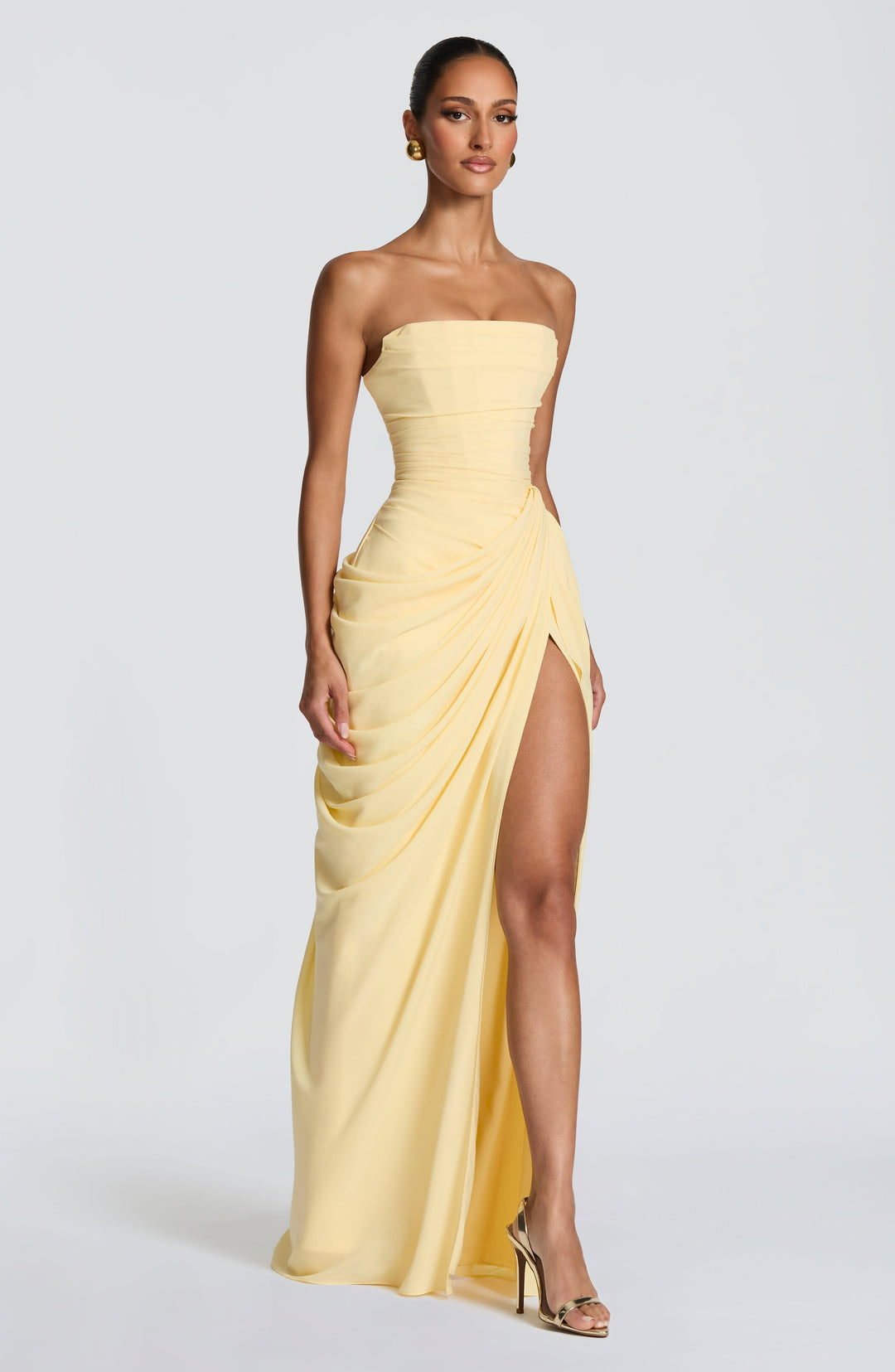 Vibrant yellow strapless maxi dress for women, featuring a chic corset bodice and daring leg split.