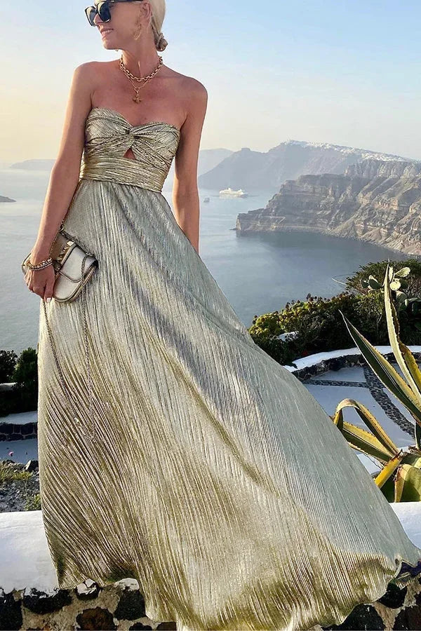 Flowy side view of a women's elegant strapless pleated maxi dress, ideal for wedding guests & special occasions.