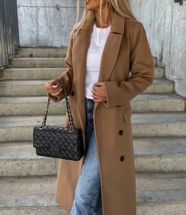 Classic women's tailored long coat with a sleek belt, embodying professional elegance for any sophisticated occasion.