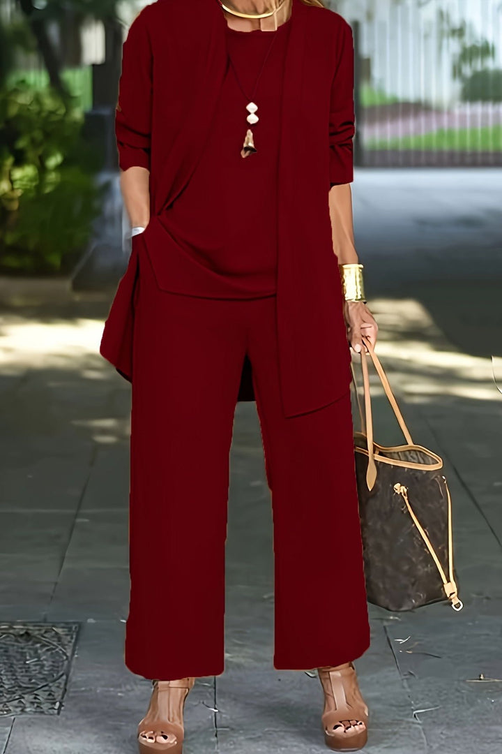 Chic women's coordinated three-piece outfit, featuring elegant top, trousers, and jacket.