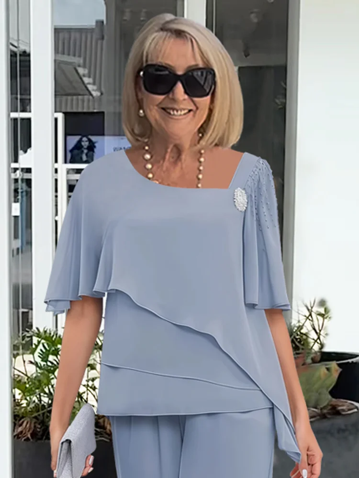 Stylish women's elegant two-piece set: a flowing cape top and classic trousers for a polished, formal look.