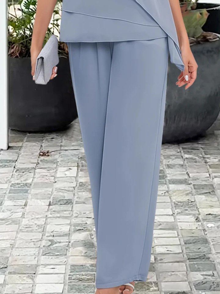 Sophisticated women's occasion wear two-piece set in light blue, featuring a cape top and comfortable trousers.