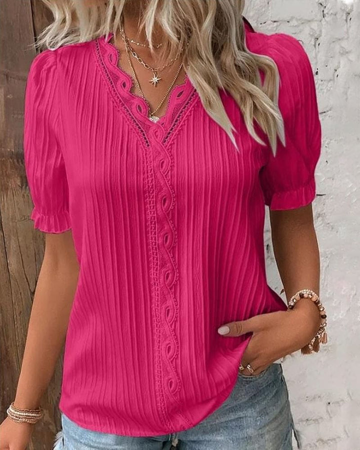 Delicate V-neck lace blouse for women. Elegant long sleeve top in a light color, ideal for sophisticated spring and summer fashion.