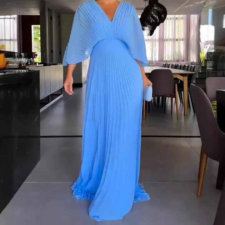 Long kaftan maxi dress featuring a flattering V-neck and pleats. Elegant women's summer occasion wear.