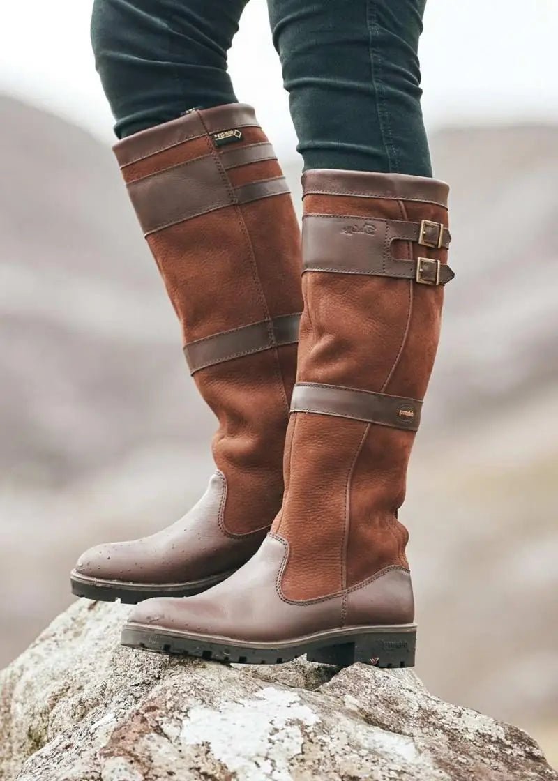 Stylish women's knee-high pull-on boots with buckle details. Waterproof and comfortable for versatile all-weather wear.