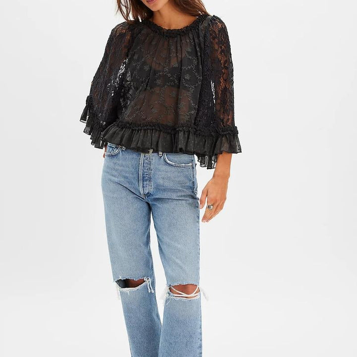 Stylish women's sheer lace blouse in white, adorned with elaborate floral embroidery and chic ruffle trim