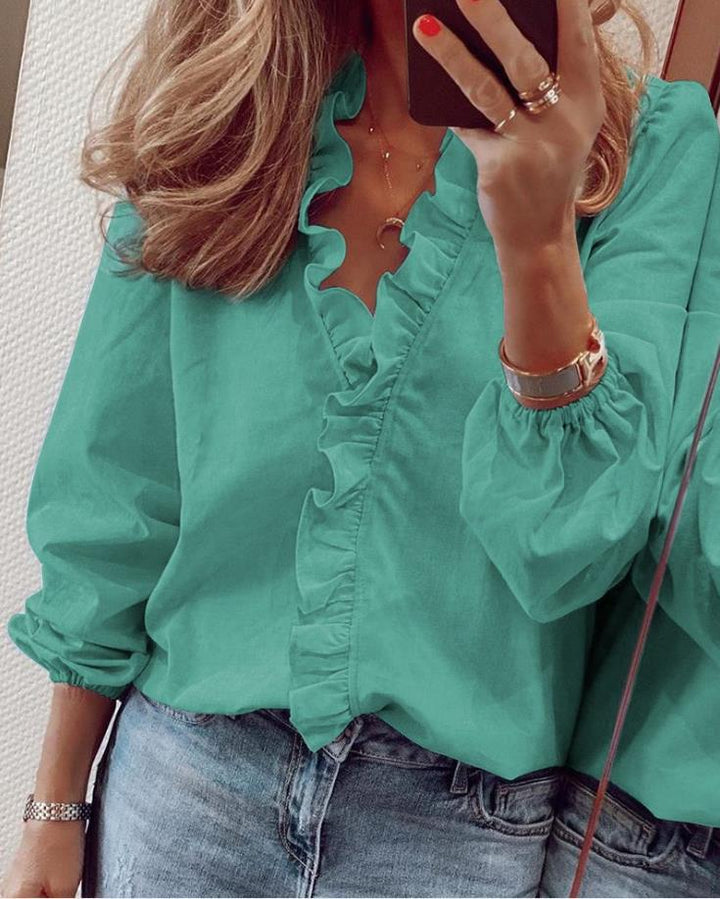 Stylish women's ruffled V-neck blouse, relaxed fit, long sleeve. An elegant top for versatile spring fashion and comfort.