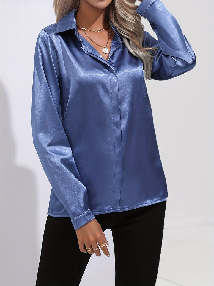Close-up of a women's satin button down blouse, highlighting the fabric's smooth texture and buttons.