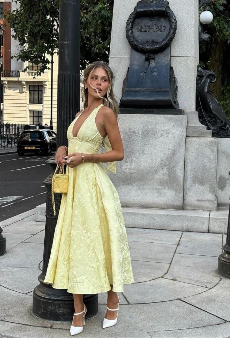 Stylish women's yellow A-line halter midi dress with a structured corset, ideal for wedding guests.