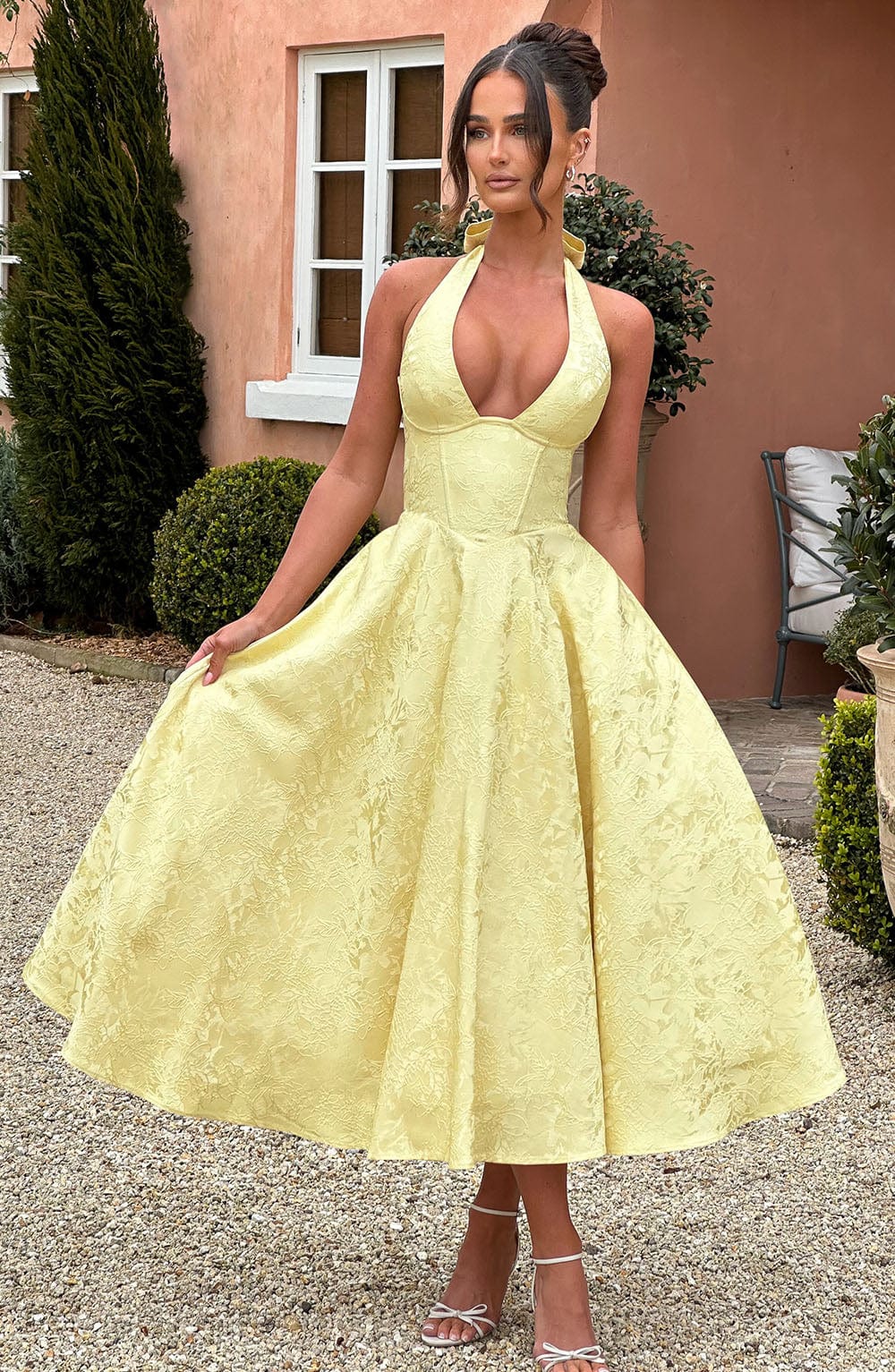 Elegant yellow women's party dress, a halter midi style with a chic corset detail for wedding guests.
