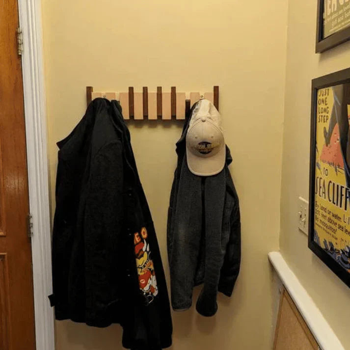 Elegant wooden piano key coat rack for entryway. Modern wall organizer with folding hooks.