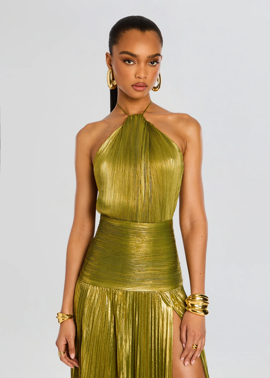 Stunning green glimmering halter maxi dress for women. Features a sophisticated pleated skirt and metallic finish for elegance.