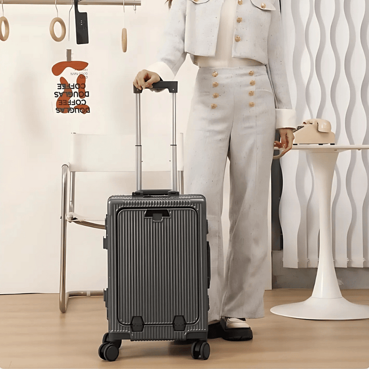 Sleek black hard-shell carry-on luggage with front pocket, USB port for charging devices.