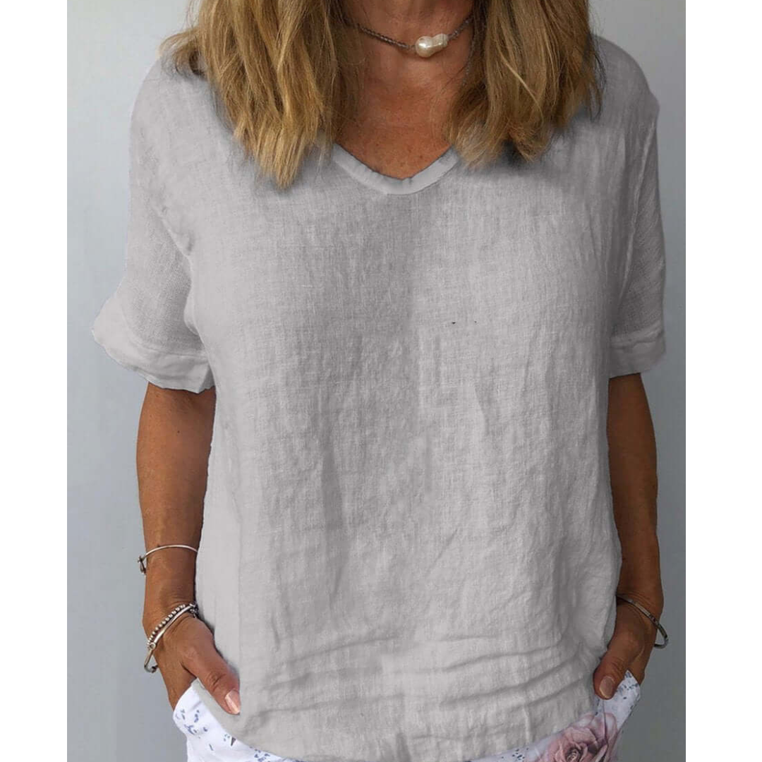 White women's V-neck short sleeve top, relaxed fit blouse for everyday essential wear. Stylish and comfortable.