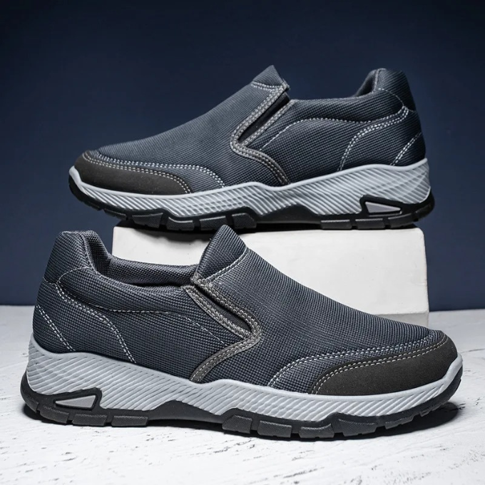 Two pairs of men's slip-on comfort shoes, one black and one gray, for casual wear