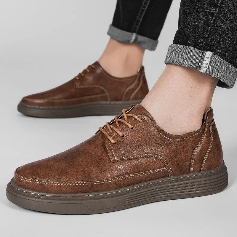 Close-up of men's brown leather dress sneaker, showcasing premium leather texture and stitching.