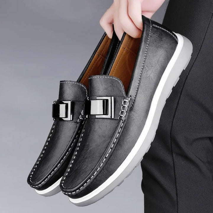 Side profile of men's leather loafer, highlighting classic design and sturdy sole.