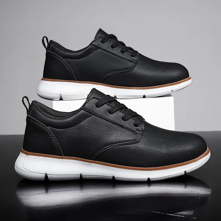 Pair of black leather lace-up sneakers for men, offering both comfort and versatile style for daily fashion.